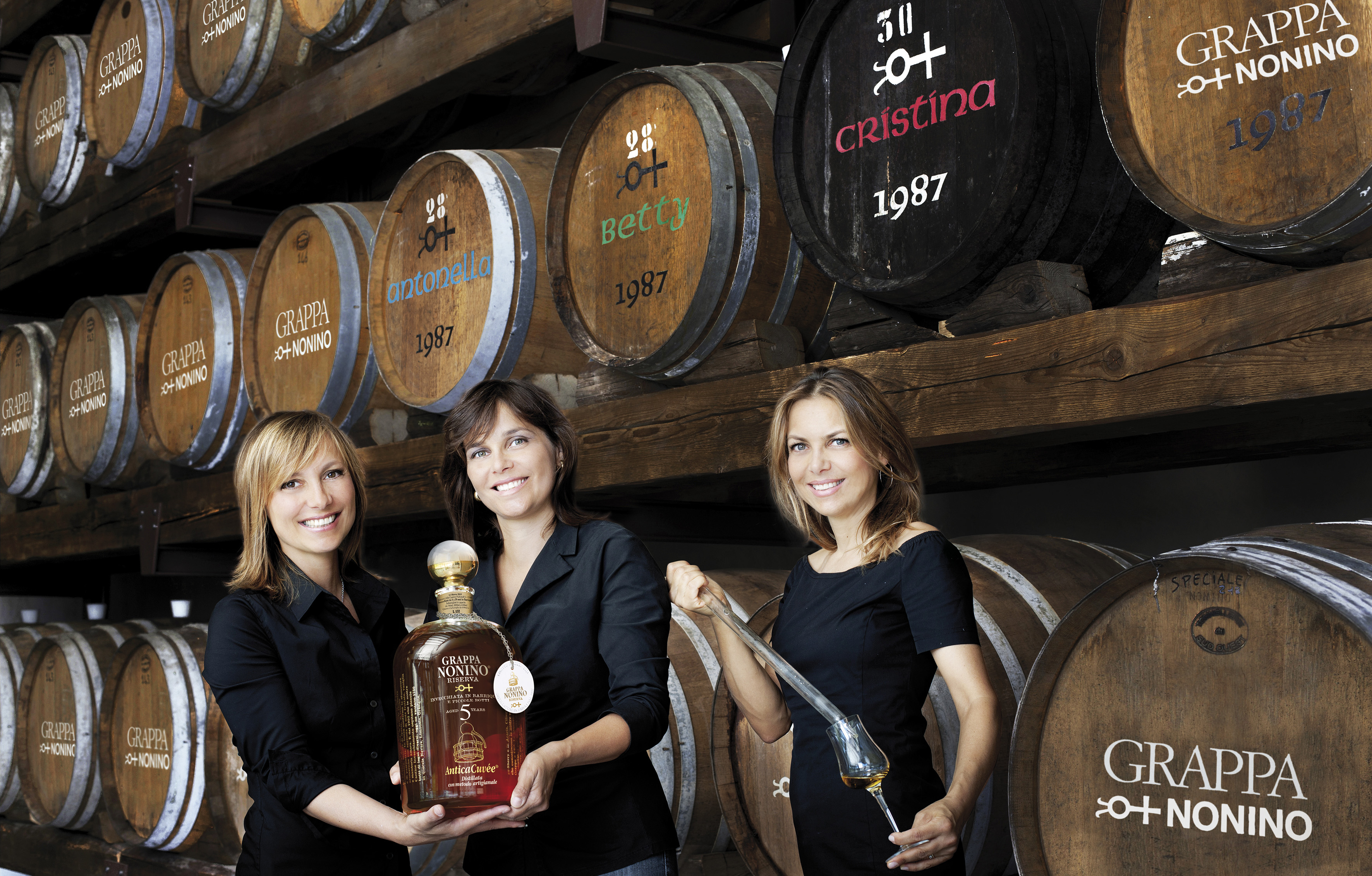 Antonella_Elisabetta_and_Cristina_Nonino_in_one_of_the_six_Nonino_Ageing_Cellars_with_Grappa_Nonino_Riserva_AntiCuvee_age_5_years
